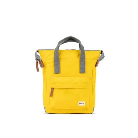 Roka Bantry B rucksack Bag in mustard available at Lotta from Stockholm Front view, a mustard yellow bag with grey straps and brown accents on zip pulls