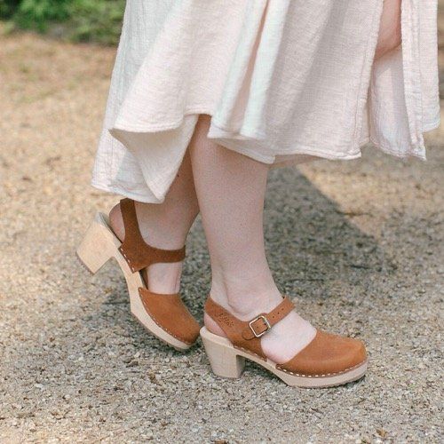 Brown clogs in oiled nubuck on a natural wooden clogs base with rubber sole by Lotta from Stockholm worn with bare feet