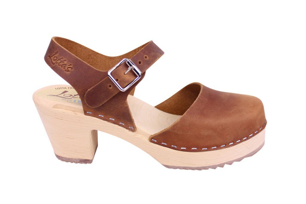 Brown clogs in oiled nubuck on a natural wooden clogs base with rubber sole by Lotta from Stockholm. Side view showing the ankle strap and buckle and Logo stamp