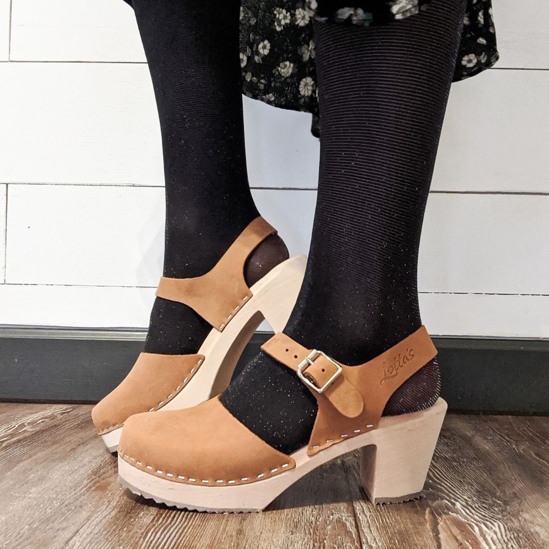 Brown clogs in oiled nubuck on a natural wooden clogs base with rubber sole by Lotta from Stockholm. Worn with black tights